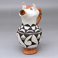 A polychrome cream pitcher with a cow head spout, twisted handle and a black-on-white geometric design around the body and neck
 by Mabel Brown of Acoma