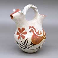 A polychrome wedding vase with a twisted bridge, a cow head on one spout and decorated around the body with a parrot, flower and vine design
 by Juana Chavez of Acoma