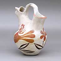 A polychrome wedding vase with a twisted bridge, a cow head on one spout and decorated around the body with a parrot, flower and vine design, click or tap to see a larger version