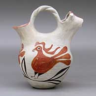 A polychrome wedding vase with a twisted bridge, a cow head on one spout and decorated around the body with a parrot, flower and vine design, click or tap to see a larger version