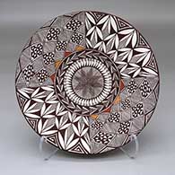 A polychrome plate with a pumpkin seed, fine line and geometric design
 by Carolyn Concho of Acoma