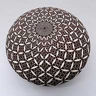 A black-on-white seed pot decorated with a North Star fine line and pumpkin seed snowflake geometric design
 by Rebecca Lucario of Acoma