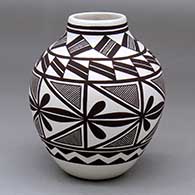 A black-on-white jar decorated with a fine line and geometric design
 by Rebecca Lucario of Acoma