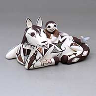 Ed is a polychrome horse with a child on its back, lizard head and bird appliques and decorated with a geometric design
 by Judy Lewis of Acoma