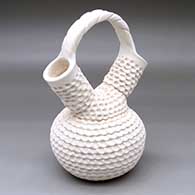 A corrugated white wedding vase with a carved cord bridge
 by Jackie Shutiva of Acoma