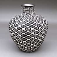 A black-on-white vase with a square neck and decorated with a spiraling geometric design
 by Paula Estevan of Acoma