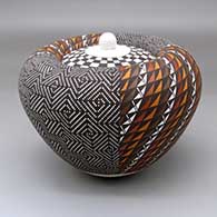 A lidded polychrome Infinity jar decorated with a four-panel geometric design around the body and a checkerboard design on the lid
 by Frederica Antonio of Acoma