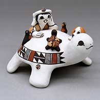 A turtle figure with a boy, puppy, turtle, birds and lady bugs on it
 by Marilyn Ray of Acoma