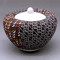 A lidded polychrome Infinity jar decorated with four-panels of geometric design
 by Frederica Antonio of Acoma