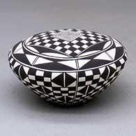 A black-on-white seed pot decorated with a checkerboard and geometric design
 by Cletus Victorino of Acoma