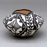 A polychrome bowl with a square opening and decorated with a four-panel geometric design
 by Sandra Victorino of Acoma