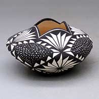 A black-on-white jar with a scalloped rim and decorated with a four-panel fine line and geometric design
 by Sandra Victorino of Acoma