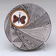 A polychrome plate decorated with a butterfly applique and a fine line and geometric design
 by Alisha Sanchez of Acoma