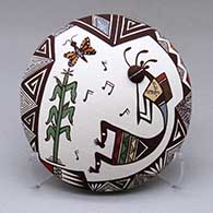 A polychrome seed pot decorated with a kokopelli, corn stalk, butterfly and geometric design
 by Carolyn Concho of Acoma