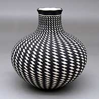 A black-on-white jar with an extended neck, a pie crust rim and a spiraling checkerboard geometric design
 by Paula Estevan of Acoma