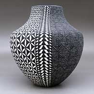 A black on white jar decorated with a four-panel fineline, yucca-leaf snowflake and geometric design, click or tap to see a larger version
