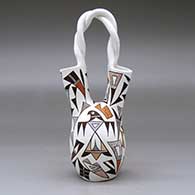 A polychrome wedding vase with a twisted handle and decorated with a butterfly, corn plant, thunderbird and geometric design, click or tap to see a larger version