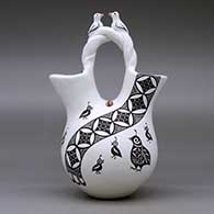 A polychrome wedding vase with a twisted bridge and decorated with lady bug, bird and butterfly appliques and painted with a corn stalk, butterfly, quail and geometric design, click or tap to see a larger version