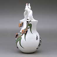A polychrome wedding vase with a twisted bridge and decorated with lady bug, bird and butterfly appliques and painted with a corn stalk, butterfly, quail and geometric design, click or tap to see a larger version