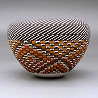 A polychrome jar with an Infinity rim and decorated with a stylized checkerboard and stripe geometric design, click or tap to see a larger version