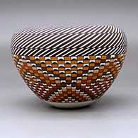 A polychrome jar with an Infinity rim and decorated with a stylized checkerboard and stripe geometric design, click or tap to see a larger version