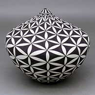A black on white tear drop jar decorated with a yucca-leaf snowflake and geometric design
 by Cletus Victorino of Acoma