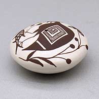 A miniature black on white seed pot decorated with a cloudeater, fish, vine and geometric design above the shoulder, click or tap to see a larger version