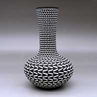 A tall neck black on white vase decorated with a geometric design, click or tap to see a larger version