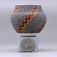 A miniature polychrome jar decorated with a four-panel geometric design, click or tap to see a larger version