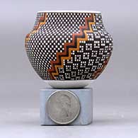 A miniature polychrome jar decorated with a four-panel geometric design, click or tap to see a larger version
