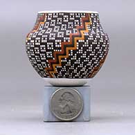 A miniature polychrome jar decorated with a four-panel geometric design, click or tap to see a larger version