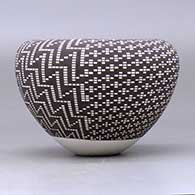 A black on white jar with an infinity rim and decorated with a four-panel geometric design built of filling in tiny squares in a grid, click or tap to see a larger version
