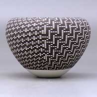 A black on white jar with an infinity rim and decorated with a four-panel geometric design built of filling in tiny squares in a grid, click or tap to see a larger version