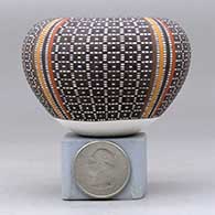 A miniature polychrome jar with an Infinity rim and decorated with a four-panel tiny-square geometric design, click or tap to see a larger version