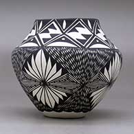 A black on white jar decorated with a four-panel fineline and geometric design, click or tap to see a larger version