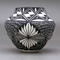 A black on white jar decorated with a four-panel fineline and geometric design, click or tap to see a larger version