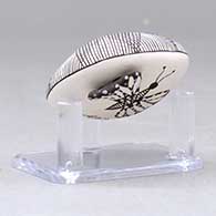 A miniature black on white seed pot decorated with a butterfly wing applique and a butterfly, fineline and geometric design, click or tap to see a larger version