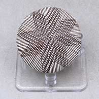 A miniature black on white seed pot decorated with a butterfly wing applique and a butterfly, fineline and geometric design
 by Alisha Sanchez of Acoma