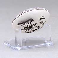 A miniature black on white seed pot decorated with a butterfly wing applique and a butterfly, fineline and geometric design, click or tap to see a larger version