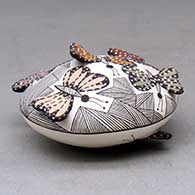 A polychrome seed pot decorated with butterfly wing appliques and a butterfly, fineline and geometric design, click or tap to see a larger version