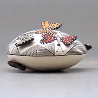 A polychrome seed pot decorated with butterfly wing appliques and a butterfly, fineline and geometric design, click or tap to see a larger version