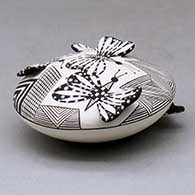 A black on white seed pot decorated with butterfly wing appliques and a butterfly, fineline and geometric design, click or tap to see a larger version