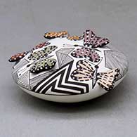 A polychrome seed pot decorated with butterfly wing appliques and a butterfly, fineline and geometric design, click or tap to see a larger version