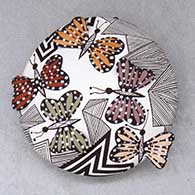 A polychrome seed pot decorated with butterfly wing appliques and a butterfly, fineline and geometric design
 by Alisha Sanchez of Acoma