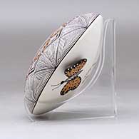 A polychrome seed pot decorated with a butterfly wing applique and a butterfly, fineline and geometric design, click or tap to see a larger version