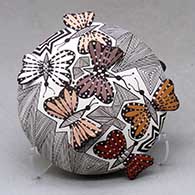 A polychrome seed pot decorated with butterfly wing appliques and a butterfly, fineline and geometric design
 by Alisha Sanchez of Acoma