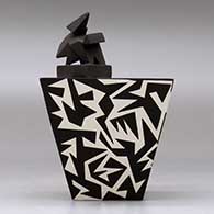 A black on white lidded pyramidal box decorated with a geometric design, click or tap to see a larger version