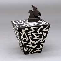 A black on white lidded pyramidal box decorated with a geometric design
 by Charmae Natseway of Acoma