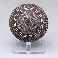 A miniature black on white seed pot decorated with a North Star fineline and geometric design above the shoulder
 by Amanda Lucario of Acoma