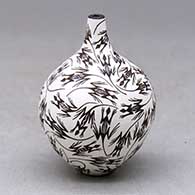 A small, black on white tall neck jar decorated with a lizard design
 by Lilly M Salvador of Acoma